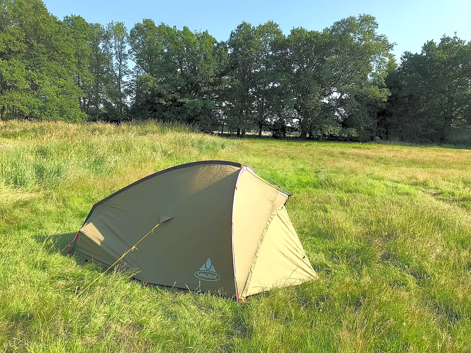 A two-person tent pitched on level grass